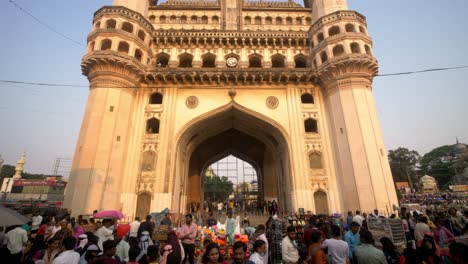 Tilt-down-shot-of-famous-historic-monument-Charminar-crowded-with-tourists-and-street-market,-Hyderabad,-India