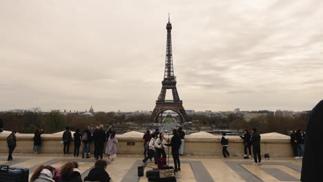People-looking-famous-Eiffel-tower-from-city-viewpoint-in-cloudy-day