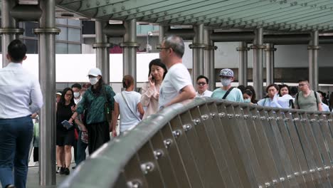 A-crowd-of-pedestrians-and-commuters-walk-through-a-city-bride