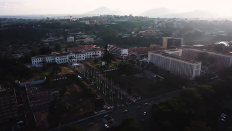 Aerial-view-panning-away-from-the-National-museum,-revealing-the-downtown-of-Yaounde,-Cameroon