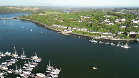 Sunny-morning-over-Kinsale-town-in-Ireland,-an-aerial-view-over-river-Bandon,-houses-and-docked-boats-in-a-marina