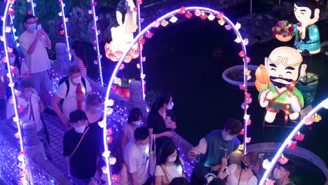 Visitantes-Chinos-Caminan-Por-Un-Puente-Decorado-Con-Luces-Mientras-Se-Toman-Selfies-Y-Disfrutan-De-Un-Espectáculo-Nocturno-De-Faroles-En-El-Templo-Wong-Tai-Sin-Durante-El-Festival-De-Mediados-De-Otoño.