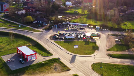 City-center-with-gas-station,-local-car-dealership-and-car-wash,-aerial-dolly-in