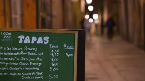 Lokales-Bar-Restaurant-Tapas-Menü-Auf-Der-Tafel-Auf-Den-Straßen-Von-Barcelona,-Spanien-Bei-Nacht,-Handheld