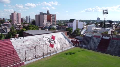 Aerial-drone-shot-flying-over-an-empty-football-field-of-Club-Deportivo-Guaraní-Antonio-Franco-in-Argentina-on-a-bright-sunny-day