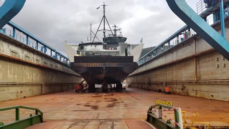 Hydrogen-powered-passenger-ship-HYDRA-from-Norled-company-is-inside-drydock-at-Westcon-shioyard-in-Olensvag-Norway---Handheld-walking-towards-shi-inside-dock