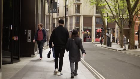 A-couple-walking-dressed-in-dark-clothes-walking-the-streets-of-london