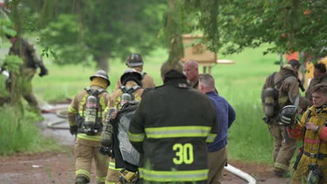 Eine-Gruppe-Von-Feuerwehrleuten-Legt-Verschiedene-Ausrüstung-An-Und-Bereitet-Sich-Darauf-Vor,-Ein-Haus-In-Brand-Zu-Setzen