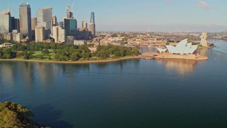 Sydney,-New-South-Wales,-Australia---25-December-2021:-Panning-left-past-the-Sydney-Opera-House-the-Sydney-Harbour-Bridge-and-the-Botanical-Gardens-and-the-buildings-of-Sydney-CBD