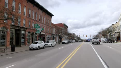 Downtown-Howell,-Michigan-on-the-street-with-cars-driving-and-video-panning-left-to-right