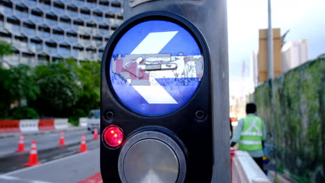 Extreme-closeup-of-a-directional-arrow-on-a-traffic-light-pole-with-road-and-vehicles-in-the-background