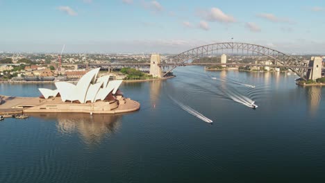 Sydney,-New-South-Wales,-Australia---24-December-2021:-Approaching-the-Sydney-Opera-House-and-Harbour-Bridge-with-boats-passing-by-in-the-harbour