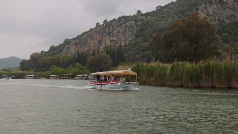 Türkisches-Touristenboot-Fährt-An-Einem-Nassen,-Windigen,-Bewölkten-Tag-Flussabwärts-Nach-Dalyan