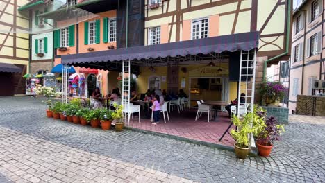 Café-Tradicional-Francés-Con-Gente-Almorzando,-Desayunando-En-Colmar-Tropicale,-Bukit-Tinggi-Malasia