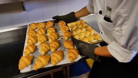 Panadero-Saca-Croissants-Recién-Horneados-Del-Horno-En-La-Cocina-De-La-Panadería,-Cocina-Francesa-De-Malasia