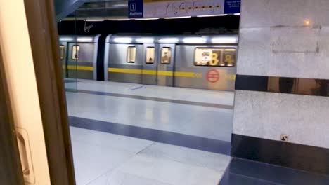 U-Bahn-Zug-Verlässt-Den-Bahnhof-Von-Einer-Anderen-U-Bahn.-Innenansicht-Am-Abend.-Das-Video-Wurde-Am-10.-April-2022-An-Der-U-Bahn-Station-Neu-Delhi,-Neu-Delhi,-Indien,-Aufgenommen