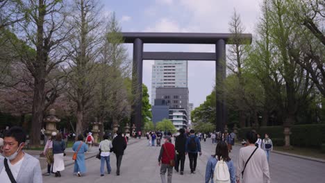 Entrance-of-Yasukuni-Shrine-in-Spring,-Japanese-People-Walking-Up-Road