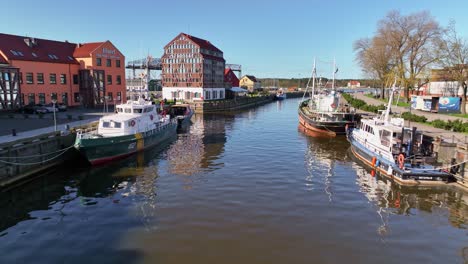 Fishing-boats-are-moored-in-the-Danes-river,-and-houses-of-various-purposes-stand-on-the-shore-in-Klaipeda-city