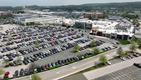 Aerial-drone-shot-of-busy-parking-lot-outside-large-American-retail-stores-and-shopping-center