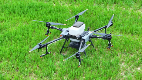 DJI-Agriculture-Drone-Agras-T30-on-Green-Farming-Field,-Hexacopter-UAV-Close-Up