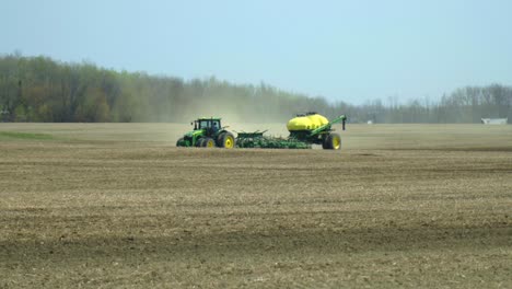 John-Deere-Traktor-Und-Luftsämaschine-Pflanzen-Ein-Feld-An-Einem-Sonnigen,-Trockenen-Frühlingstag-Im-Norden-Ontarios