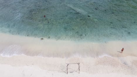 Menschen,-Die-Auf-Weißem-Sand-Spazieren-Und-Im-Türkisfarbenen-Wasser-Des-Atuh-Beach,-Insel-Nusa-Penida,-Bali,-Indonesien,-Schwimmen