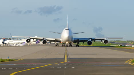 Zoomen-Sie-Aus-Einem-Großen-B747-Verkehrsflugzeug-Heraus,-Das-Bei-Tageslicht-über-Den-Flughafen-Rollt