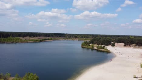People-enjoying-a-sunny-day-at-the-lake-beach-of-the-Sahara,-in-Lommel,-Belgium