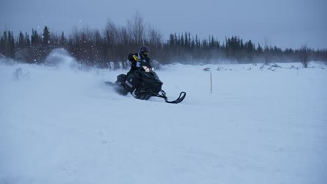Snowmobile-racer-takes-corner-while-looking-back-in-slow-motion