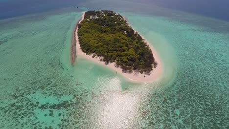 Un-Dron-Se-Desliza-Hacia-Una-Lejana-Isla-De-Garzas-Mientras-Vemos-Que-Está-Rodeada-De-Aguas-Y-Arrecifes-Verdes-Y-Azules-Claros