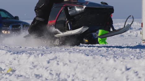 Das-Yamaha-Phazer-Schneemobil-Drag-Race-Startet-In-Zeitlupe,-Während-Der-Skilift-Hochfährt-Und-Der-Schnee-Von-Der-Strecke-Fliegt