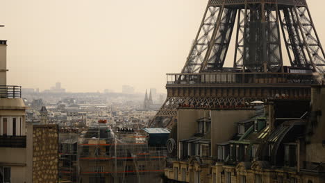 Focused-shot-of-the-lower-part-of-the-Eiffel-Tower-surrounded-by-buildings-in-a-built-up-area