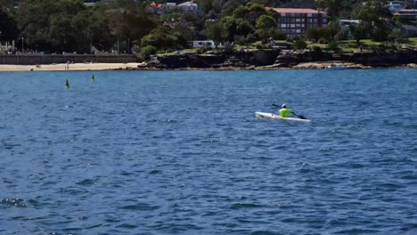 A-lone-kayaker-paddles-back-to-shore,-having-enjoyed-the-calm-waters-around-Balmoral-Beach,-a-popular-vacation-destination-in-Sydney