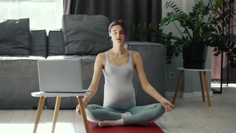 Mujer-Embarazada-Haciendo-Yoga-En-Línea-En-Casa-En-Postura-De-Loto.