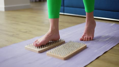 Close-up-of-woman's-feet-stepping-on-sadhu-board-indoors-at-home