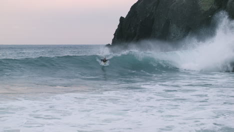 Pan-shot-of-surfer-riding-wave-at-Izu-Peninsula,-Japan