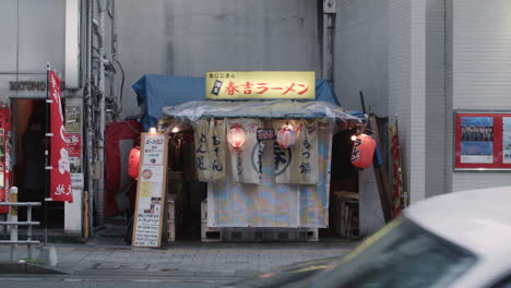 Straßenverkehr-Und-Fußgänger,-Die-An-Einem-Kleinen-Japanischen-Laden-Auf-Der-Straße-In-Nagasaki,-Japan,-Vorbeifahren