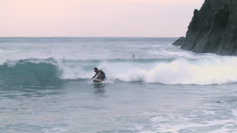 Surfer-catching-and-riding-wave-at-Izu,-Japan