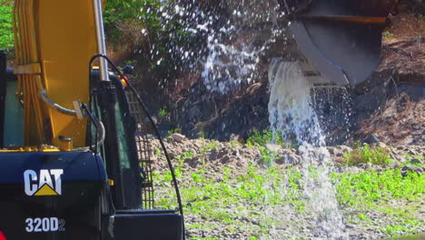 A-Backhoe-is-Cleaning-the-Dirt-Using-The-River-Water