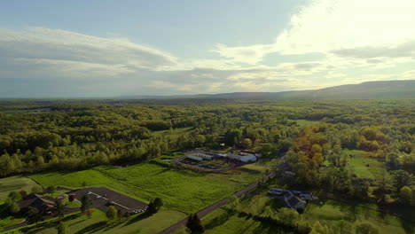 Drone-Vuela-Sobre-El-Hermoso-Cielo-De-La-Hora-Dorada-Hacia-Un-Lugar-De-Celebración-De-Bodas-En-Tierras-De-Cultivo-Del-Norte-Del-Estado-De-Nueva-York