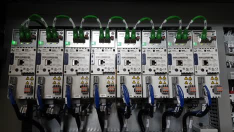 Static-CLOSE-UP-shot-of-a-series-of-industrial-inverter-drives-with-flickering-green-leds-in-a-electrical-cabinet-of-a-running-machine