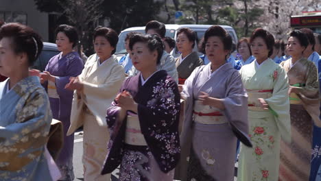 Line-of-women-in-kimono-dancing-a-traditional-cherry-blossom-dance-on-the-Kamamura-festival-in-Japan