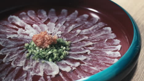 Hands-using-Chop-Sticks-to-dip-thinly-sliced-fish-in-sauce,-Kyoto,-Japan