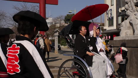 Hochzeitspaar-Sitzt-Auf-Einer-Gezogenen-Rikscha-In-Kamakura,-Japan