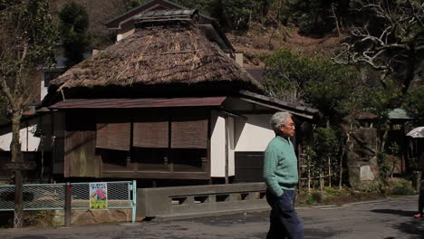 Edificio-Con-Techo-De-Paja-En-Kamakura-Con-Gente-Caminando,-Japón