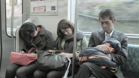 Gente-Durmiendo-En-Un-Tren-En-Movimiento-En-Japón-Después-De-Un-Largo-Día-De-Trabajo.