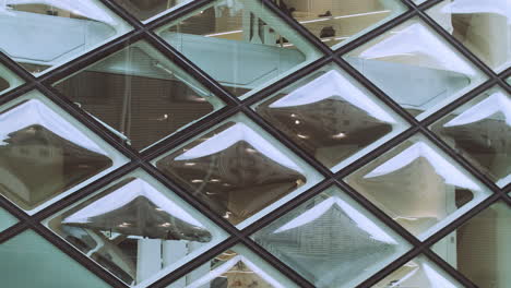 Statische-Ansicht-Der-Geometrischen-Diamantglasfenster-Im-Prada-Laden-In-Der-Innenstadt-Von-Tokio,-Während-Menschen-Vor-Der-Szene-Vorbeigehen