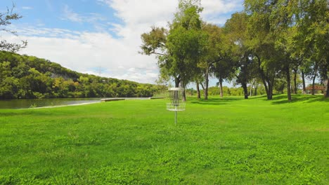 Aerial-flight-in-Cameron-Park-East-in-Waco-Texas-in-USA,-close-to-wide-shot-moving-away-from-Dynamic-Discs-Golf-Basket