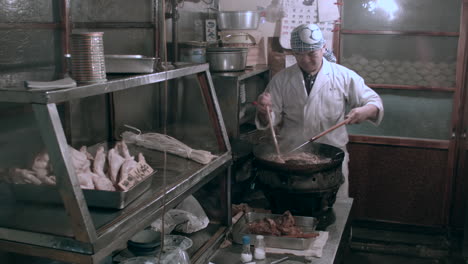 Chef-Asiático-Preparando-Pollo-En-Una-Antigua-Tienda.