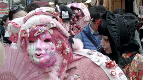 Eine-Person-In-Einem-Aufwendigen-Rosafarbenen-Kostüm-Bleibt-Stehen,-Um-In-Einem-Modeviertel-In-Tokio-Zu-Posieren